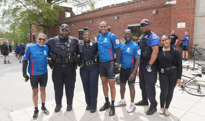 Wounded warriors, proudly wearing their WWP riding gear, are smiling at the camera while taking a picture with some local law enforcement officers.