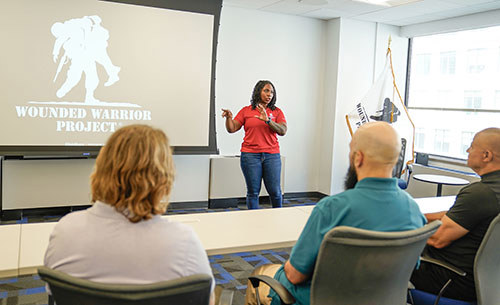 A warrior talks to other warriors in a classroom setting.