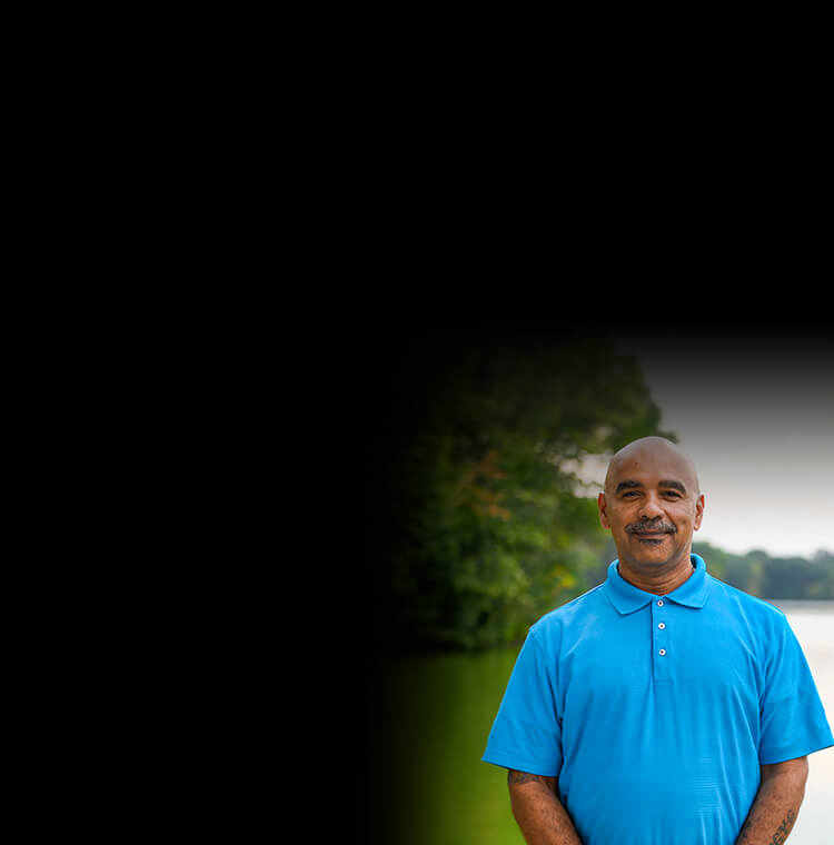 Wounded warrior Bill Thomas standing in front of a lake