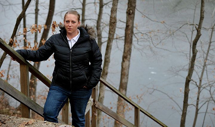 Warrior Angie Peacock stands on a flight of stairs outside while resting her hand on the banister.