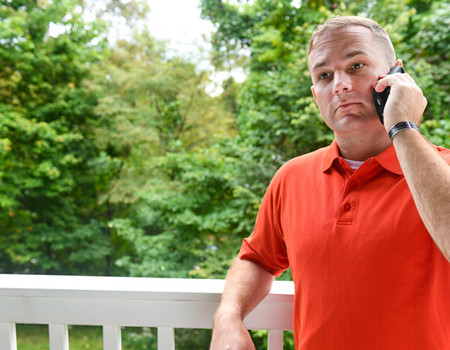 Wounded warrior Mike Heller stands outside while on the phone.