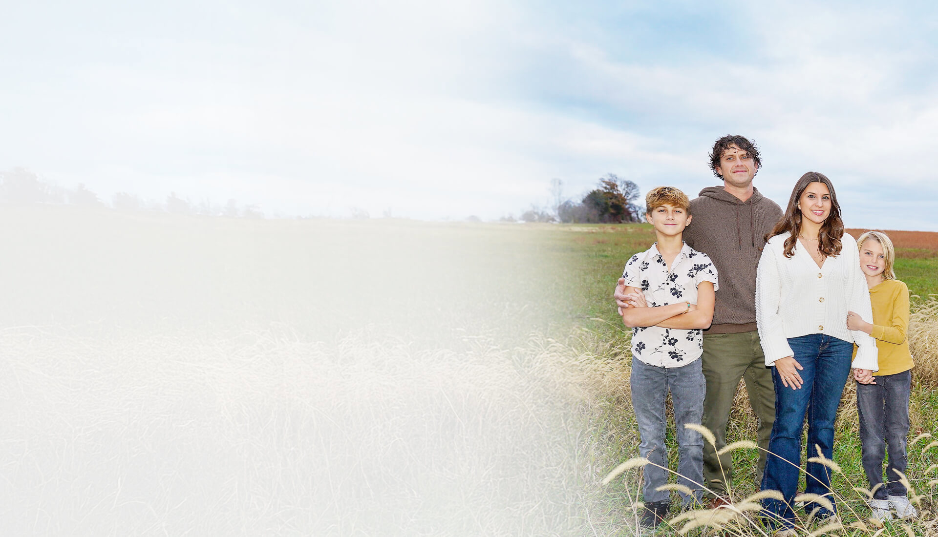 Wounded warrior Keara Torkelson stands in a field with her husband and two young sons.