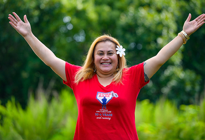 Wounded warrior Pele Hunkin smiles while raising her arms in a celebratory motion.