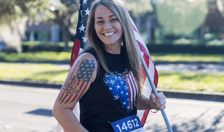 Female runner holding a flag during the Carry Forward race.