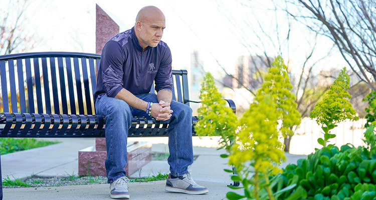 Warrior Joe Stably sits on a park bench_750x400