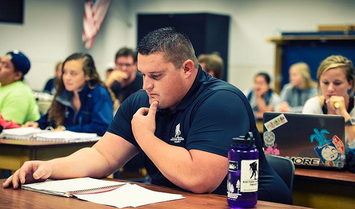 Warrior Brian Wagner sits at a table while looking at a notebook in front of him.