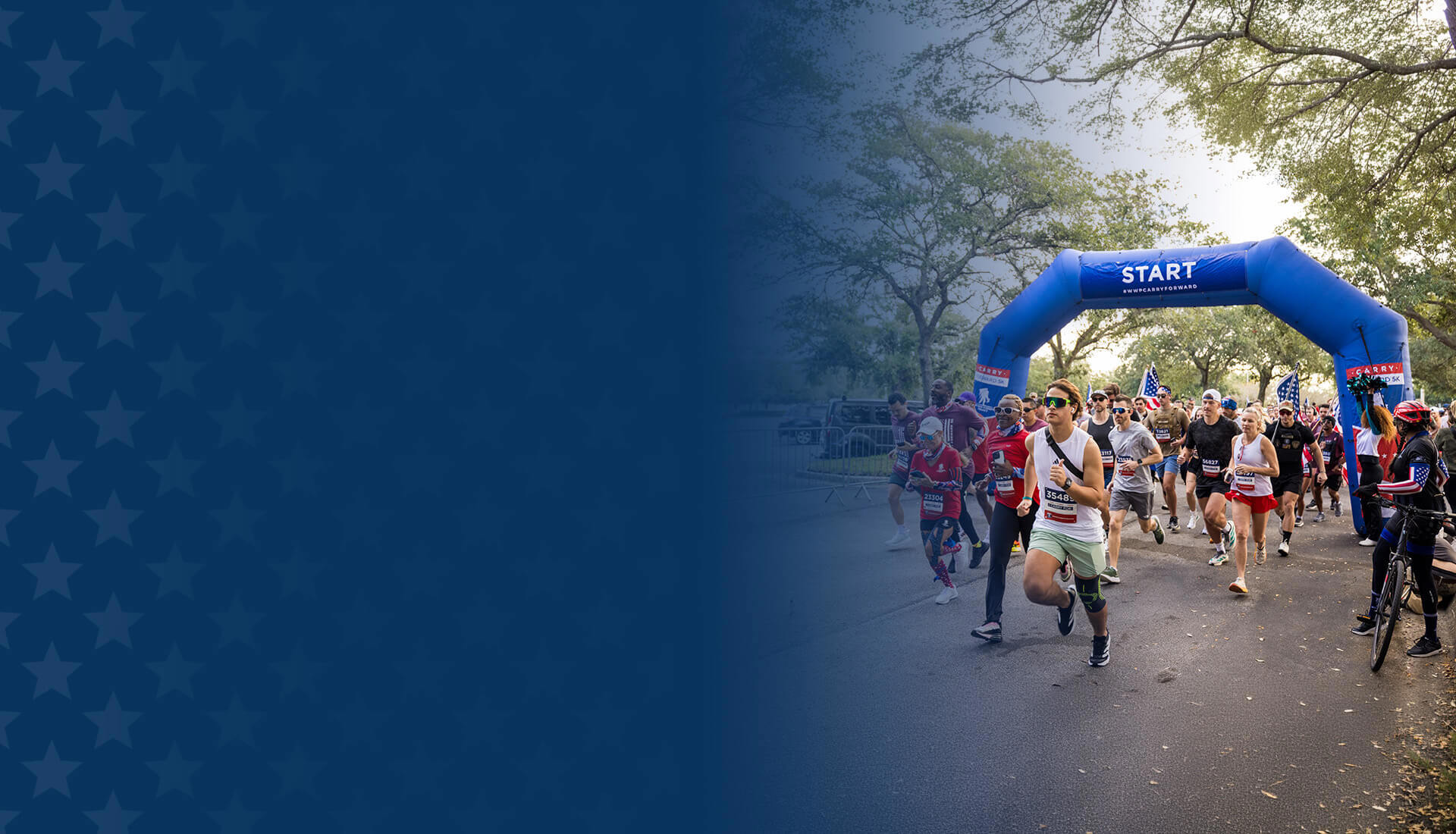 A group of runners begin a Carry Forward 5K event under a blue ‘Start’ arch.