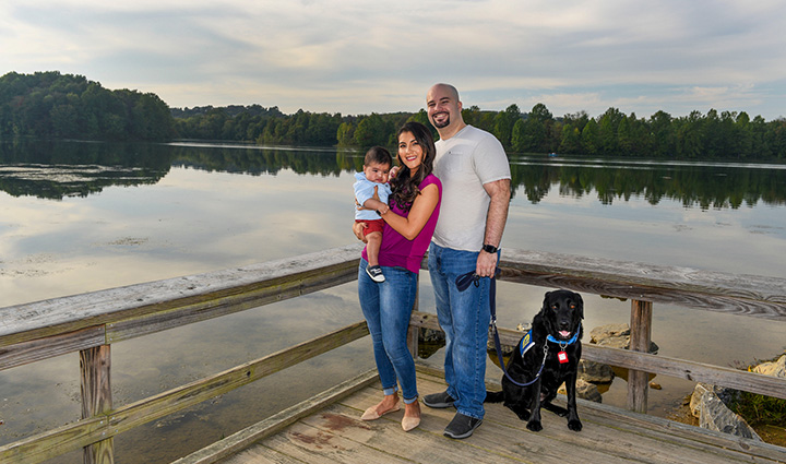 Wounded warrior Michael Carrasquillo and his family posing for the camera in front of a lake.