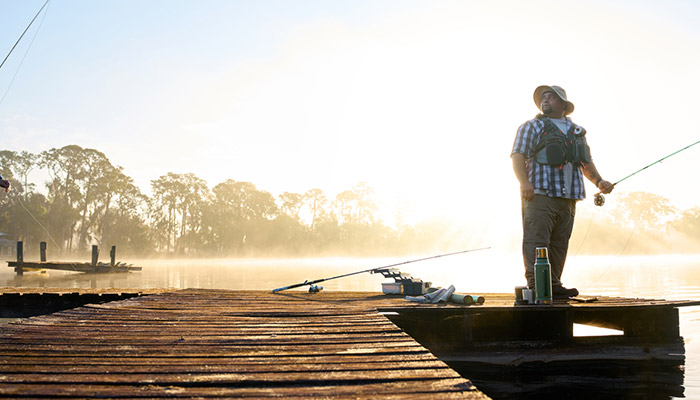 Wounded warrior Tim Aponte standing on a dock fishing.