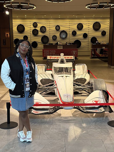 WWP warrior Chante Franco in front of racecar at Indy 500.