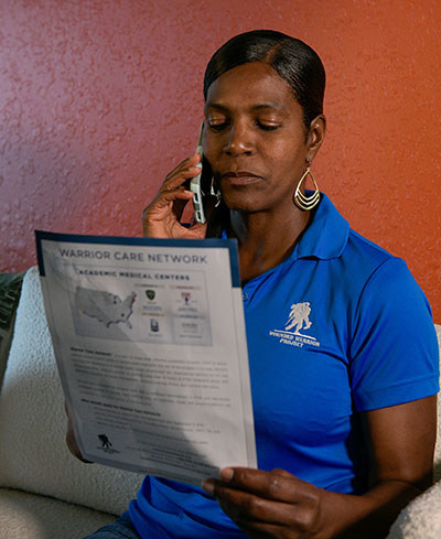 Woman veteran looks at a Warrior Care Network info sheet about virtual reality and healing.