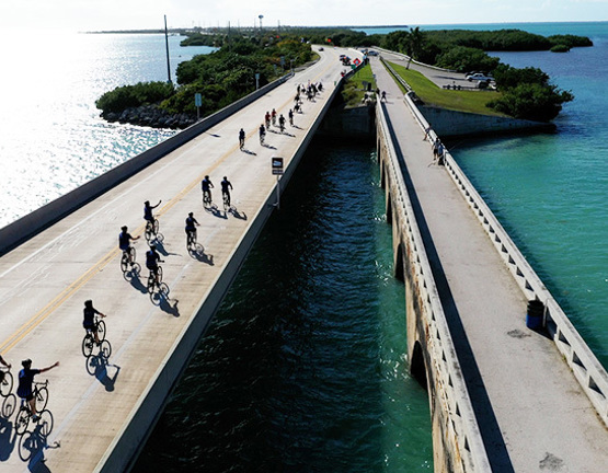 Aerial view of Soldier Ride cyclists crossing a bridge over water on the route from Miami to Key West.