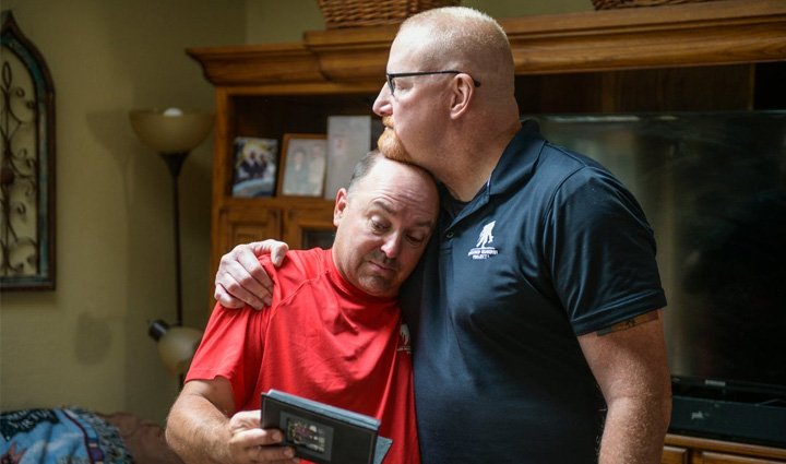 Warriors Nick Bennett and Dan Miller served together in Iraq and reflect on their time together while looking at a photo album.