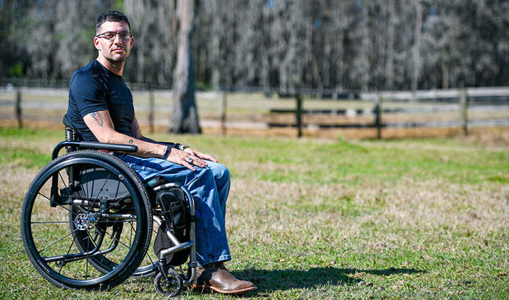 Warrior Mark Lalli in a wheelchair at a horse farm where he helps veterans and disabled people in his community.