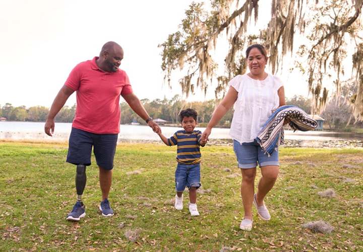 Wounded warrior Chris Gordon walks in a park holding hands with his family.