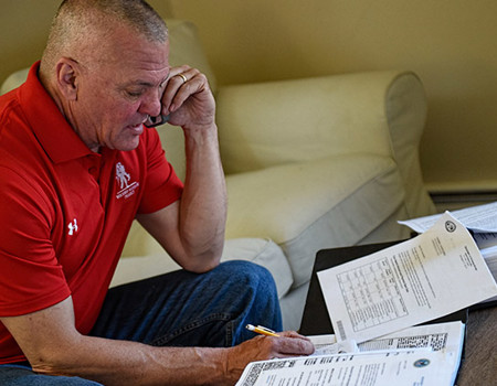 Wounded Warrior Thomas Kowolenko reviews paperwork while talking on the phone.