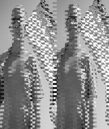 Wounded warrior James Rivera wearing a WWP t-shirt and holding an American flag.